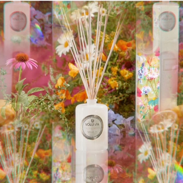 White reed diffuser bottle with floral packaging and colorful flowers