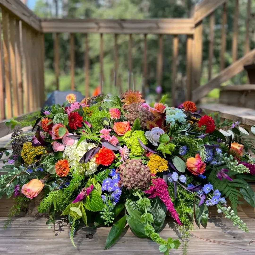 Large colorful floral arrangement on a wooden deck