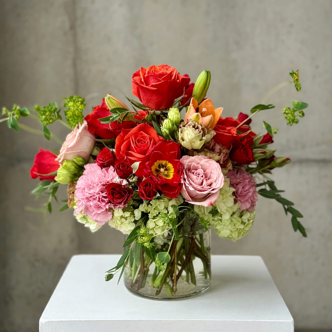 Mixed bouquet of red and pink roses in a clear glass vase