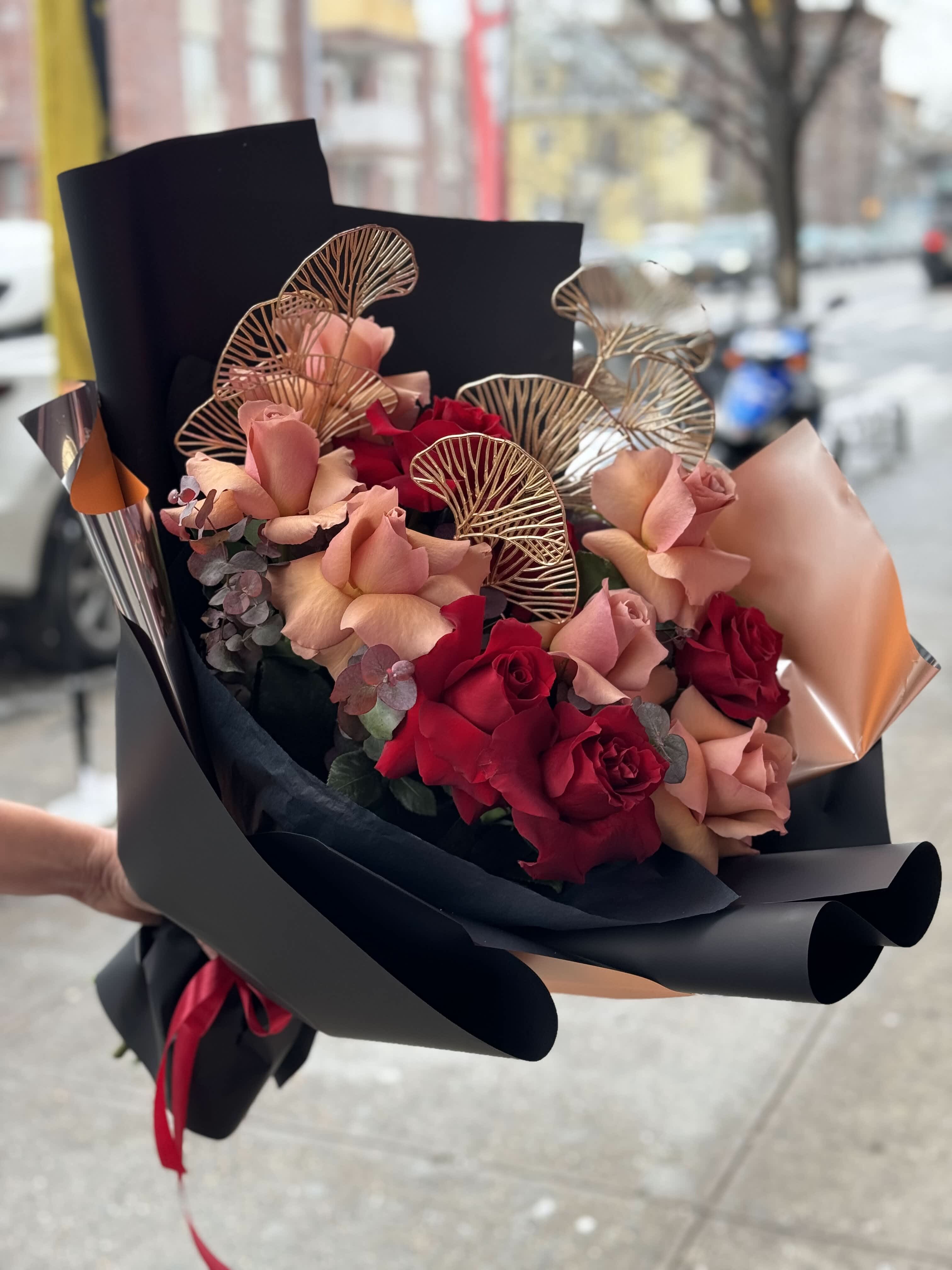 Bouquet of red and blush roses wrapped in black paper