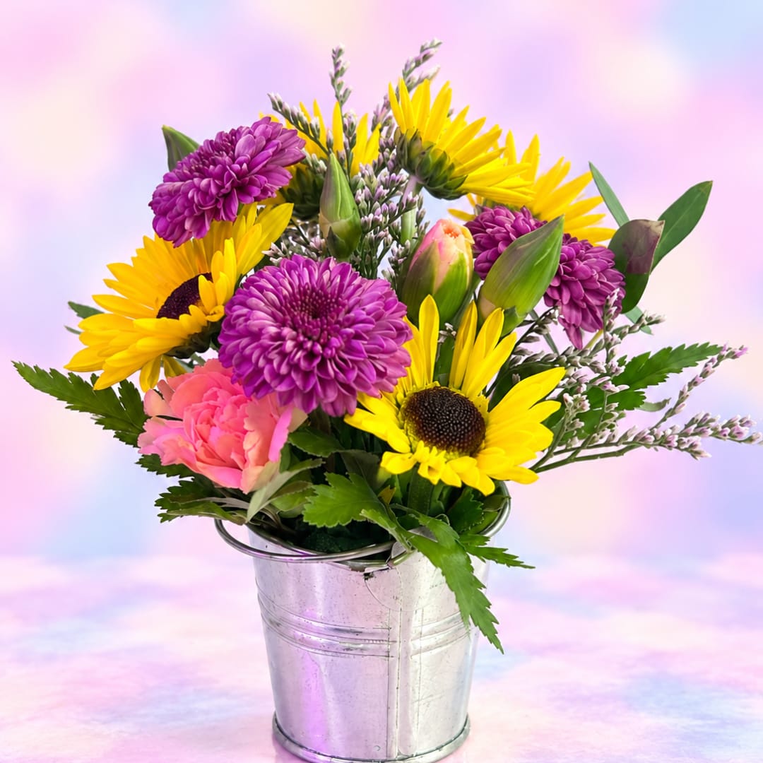Bouquet of yellow sunflowers and purple chrysanthemums in a metal bucket