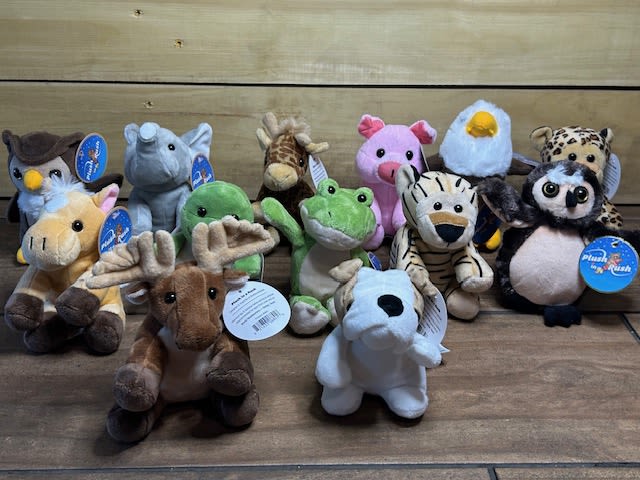 Assorted plush animal toys arranged on a wooden surface