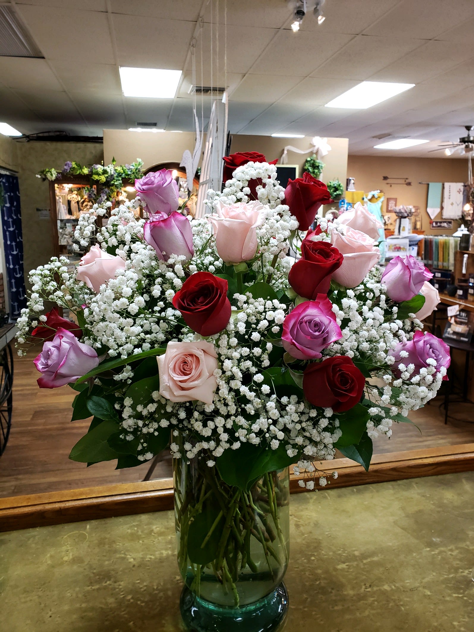 Bouquet of red, pink, and lavender roses in a glass vase