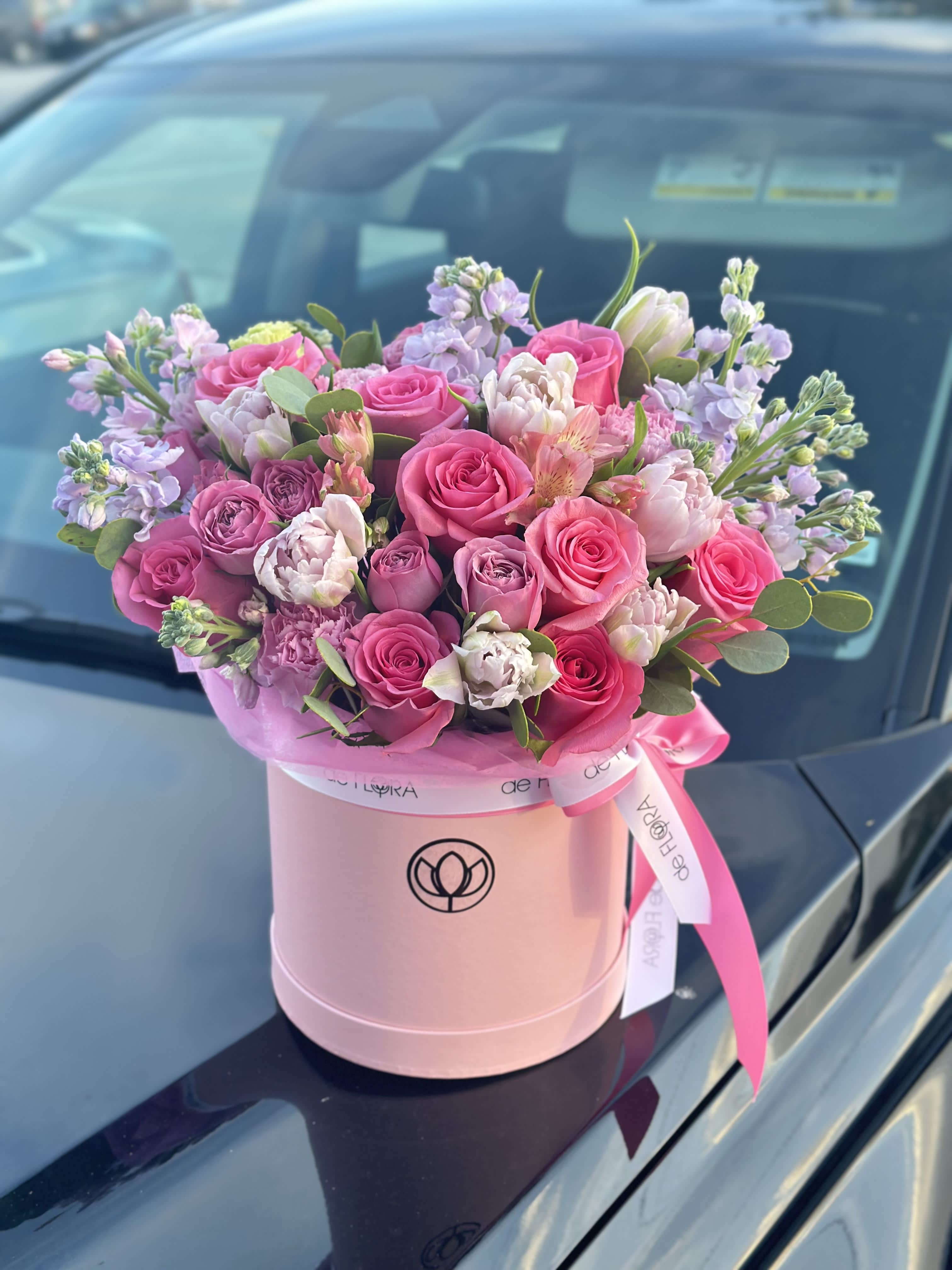 Pink and lavender rose bouquet in a round pink box with ribbon