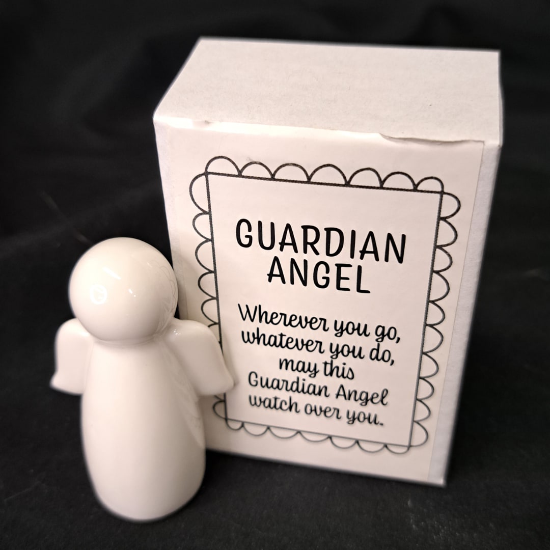 White guardian angel figurine beside a matching gift box