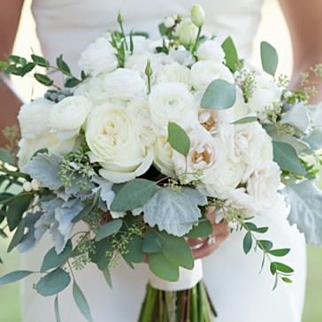White bridal bouquet with roses and ranunculus, accented by eucalyptus