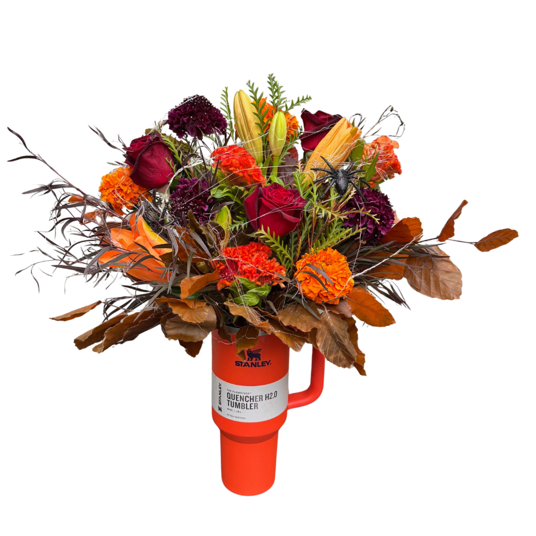 Bouquet of red, orange, and purple flowers in an orange tumbler