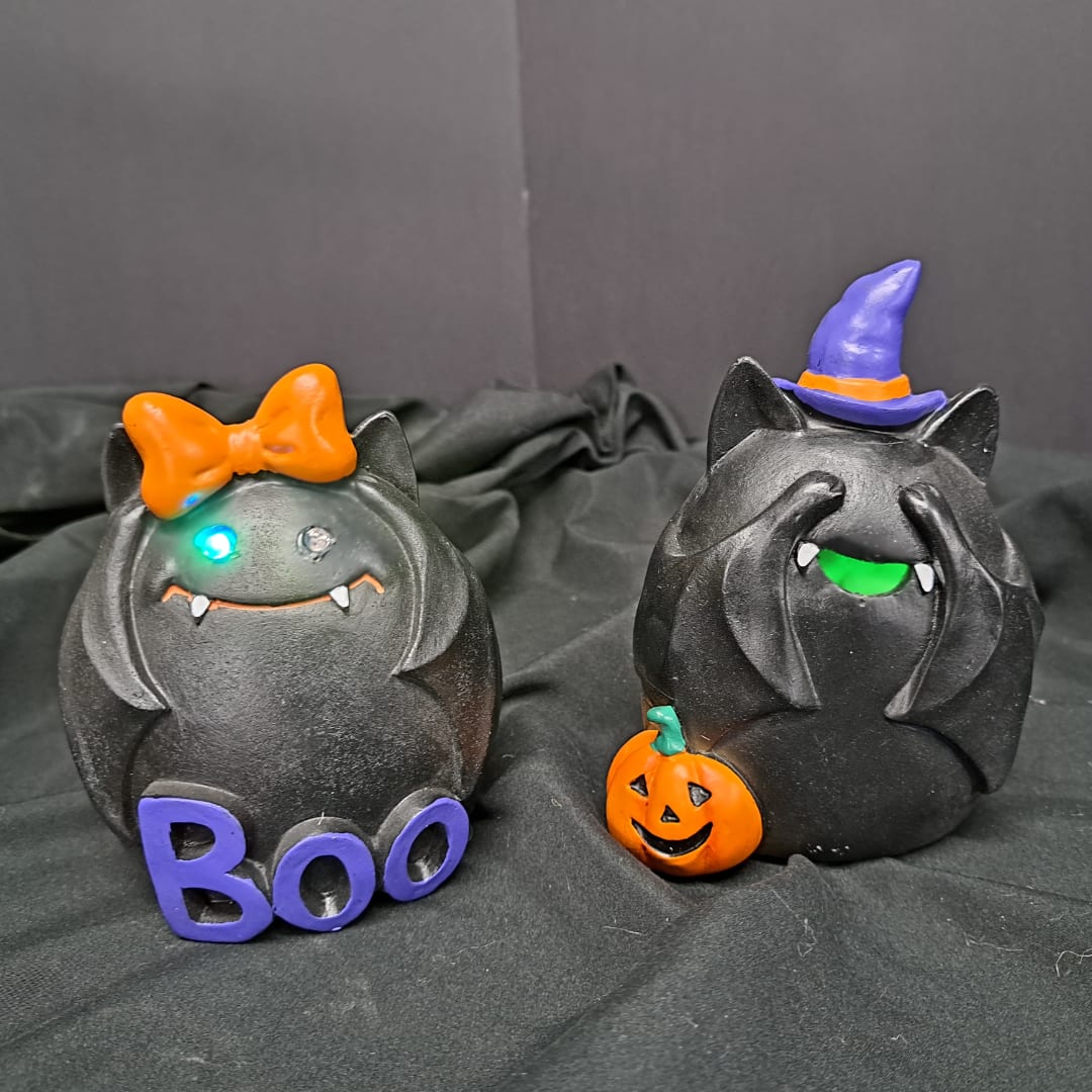 Two black Halloween cat figurines with a bow and witch hat