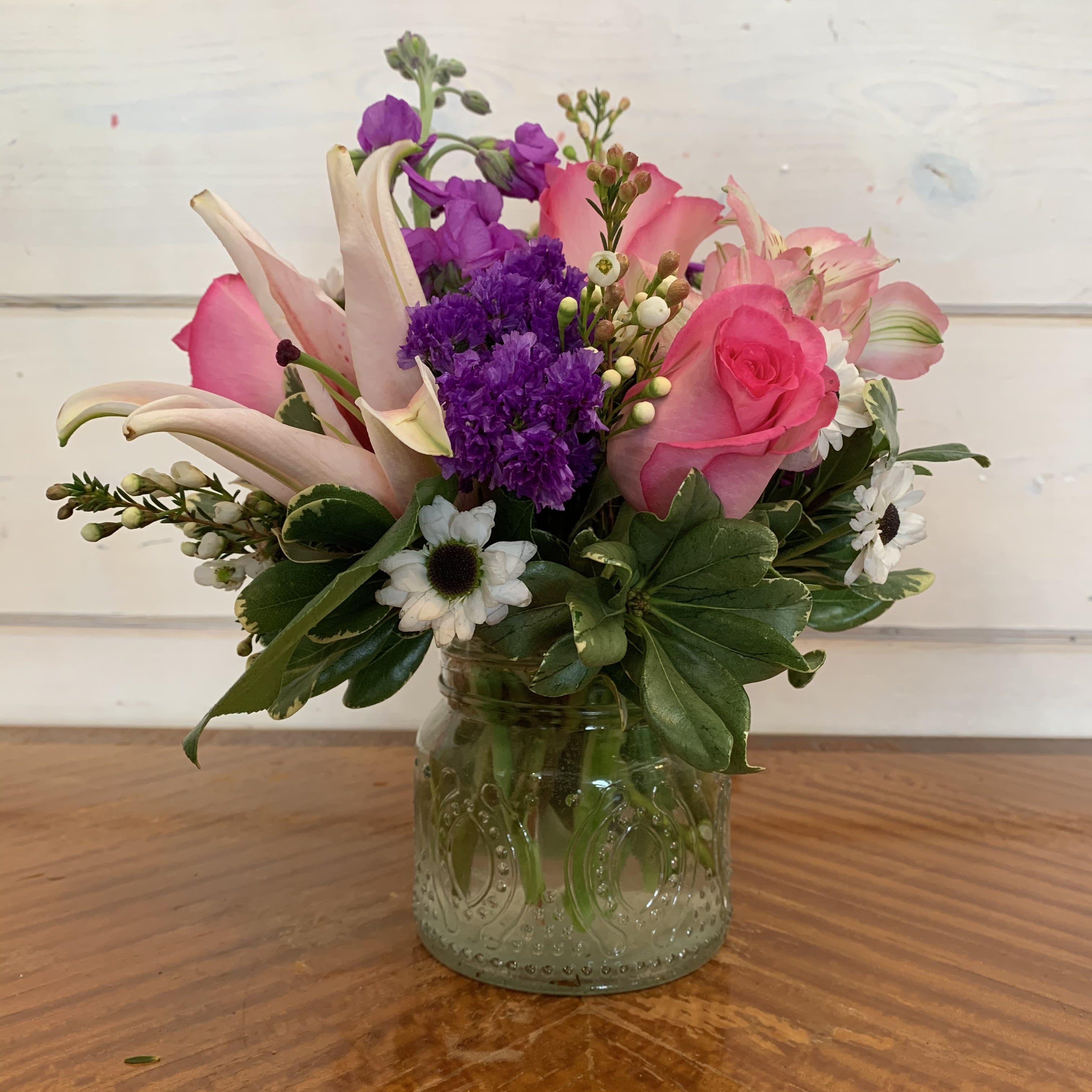 Pink and purple mixed bouquet in a glass jar vase