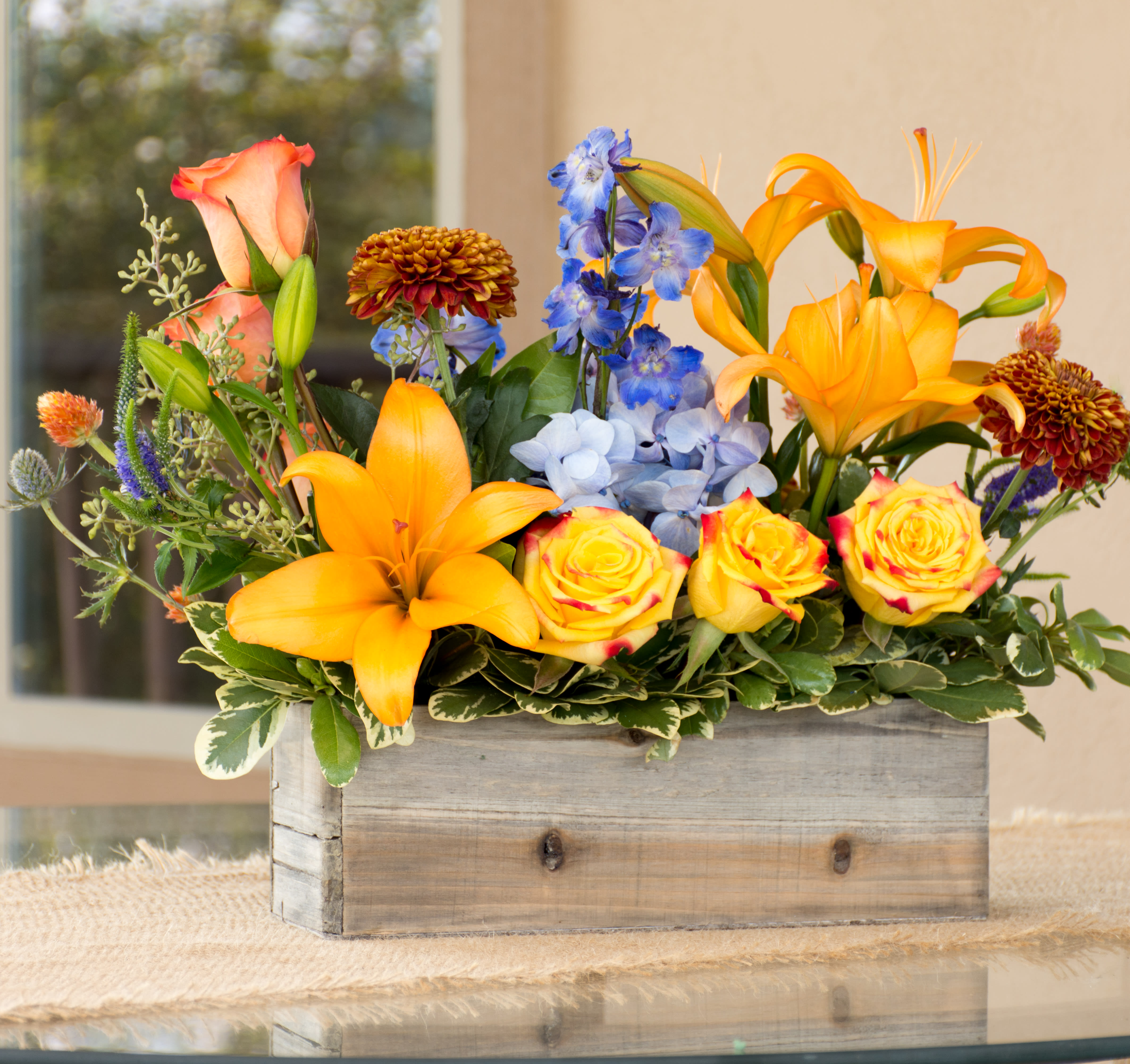 Country Classic - in a 12" x 4" wooden box with a mix of fall flowers. Lilies, roses, delphinium, mums. 