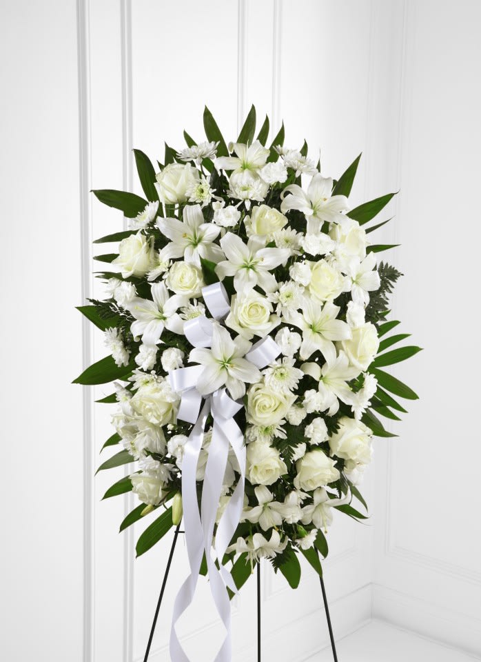 White floral standing spray with ribbon on an easel