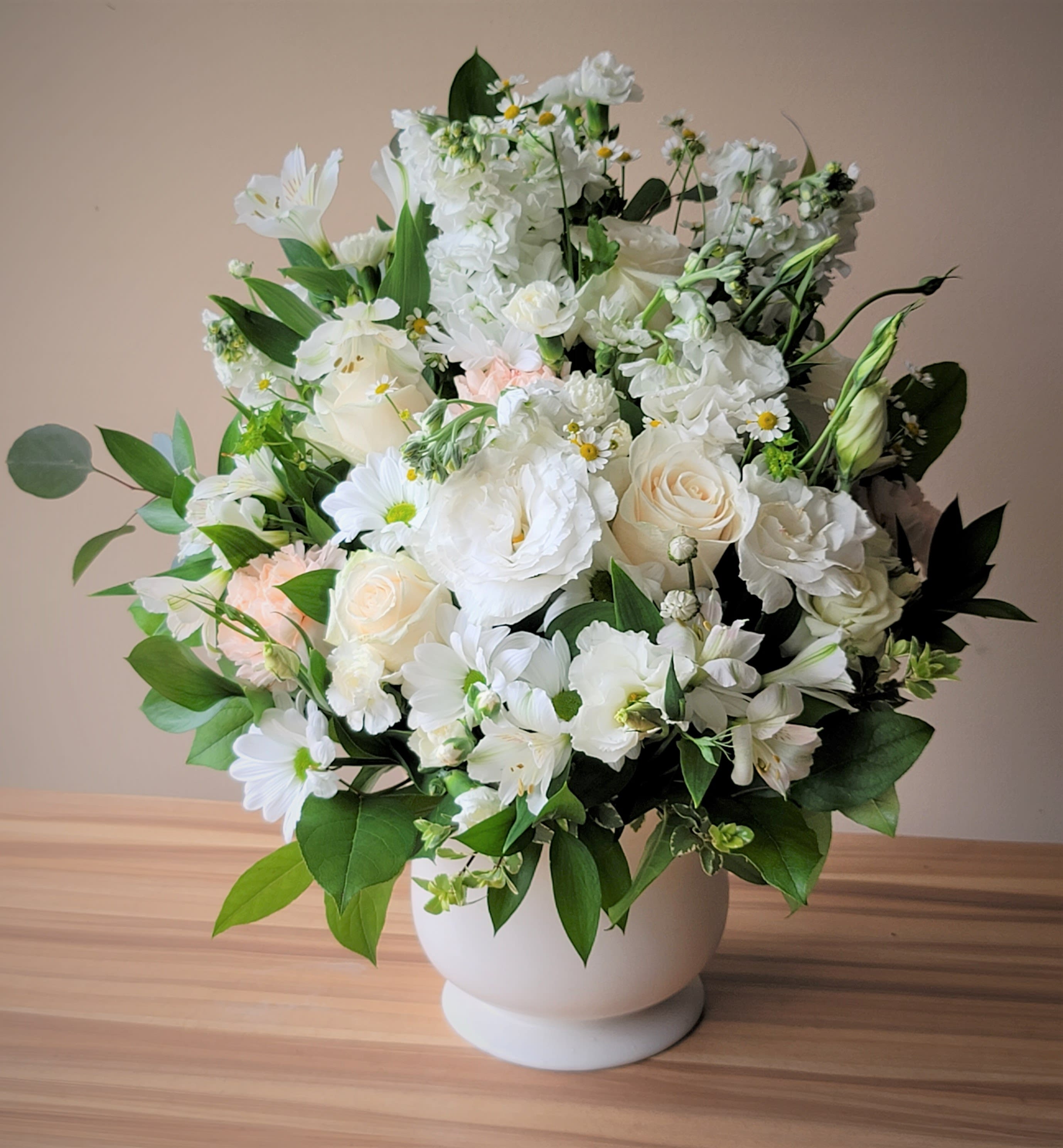White floral arrangement in a round white vase