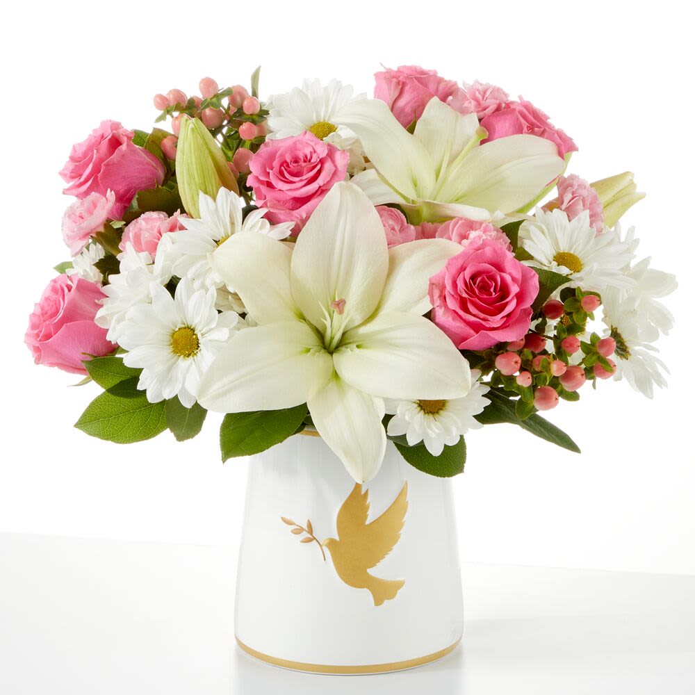 Pink roses and white lilies in a white vase with a gold dove design