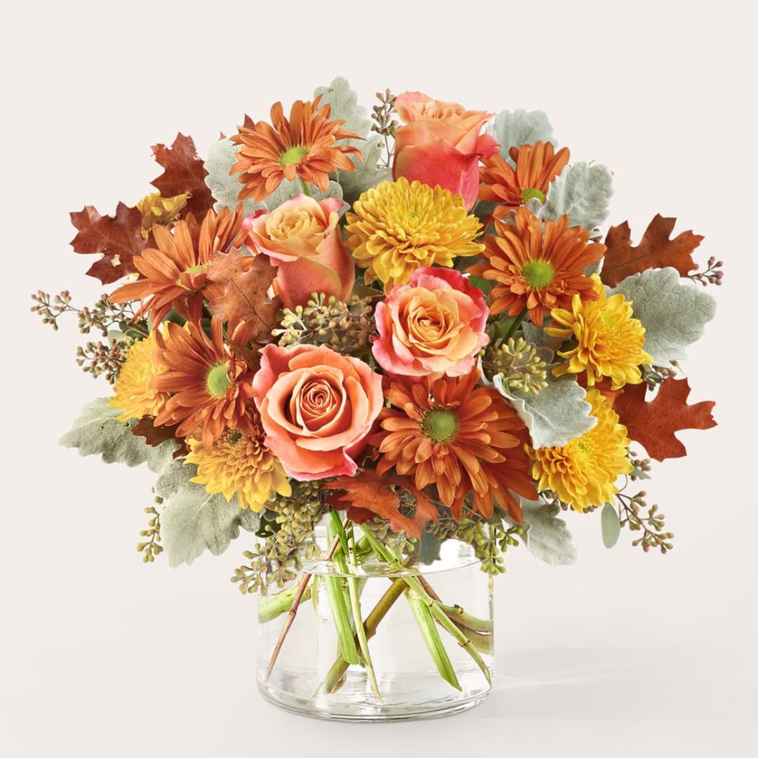 Orange and yellow flowers in a clear glass vase