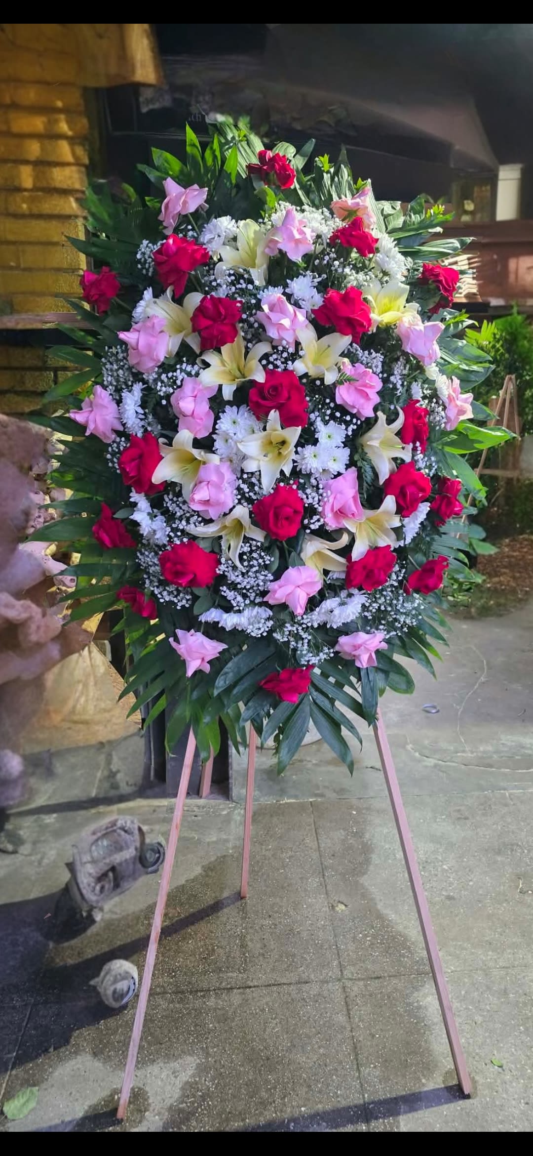 Bella   - Funeral arrangement with red and pink roses and lilis  . Perfect for a ceremony to celebrate the life of your loved one