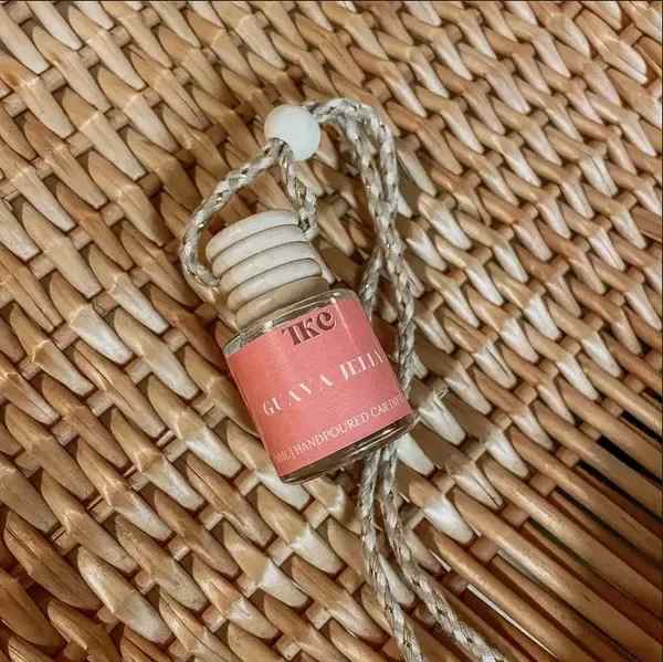 Small glass hanging bottle with a pink label and braided cord