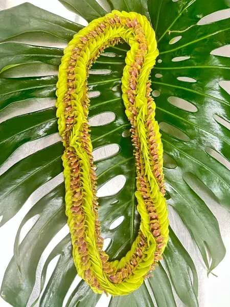 Yellow flower lei on large green leaves