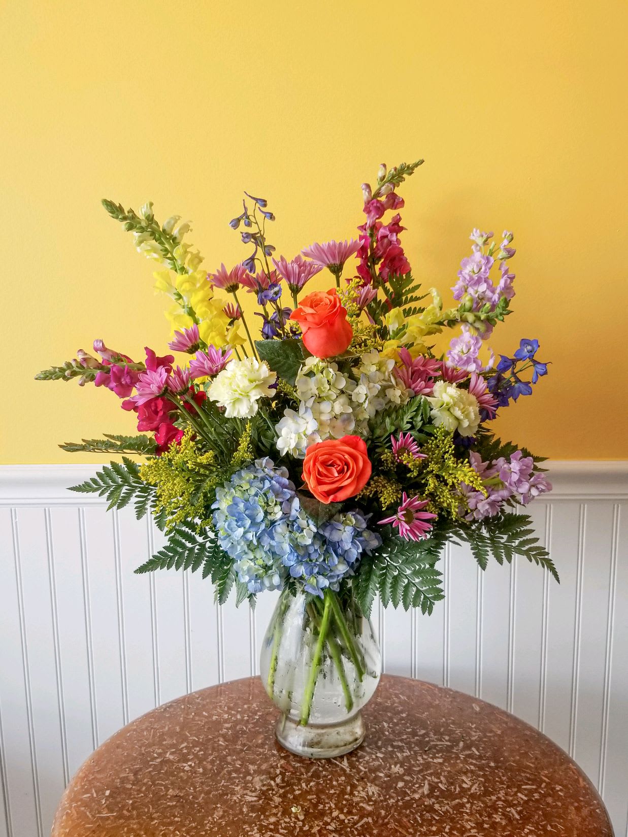 Colorful mixed flower arrangement in a clear glass vase
