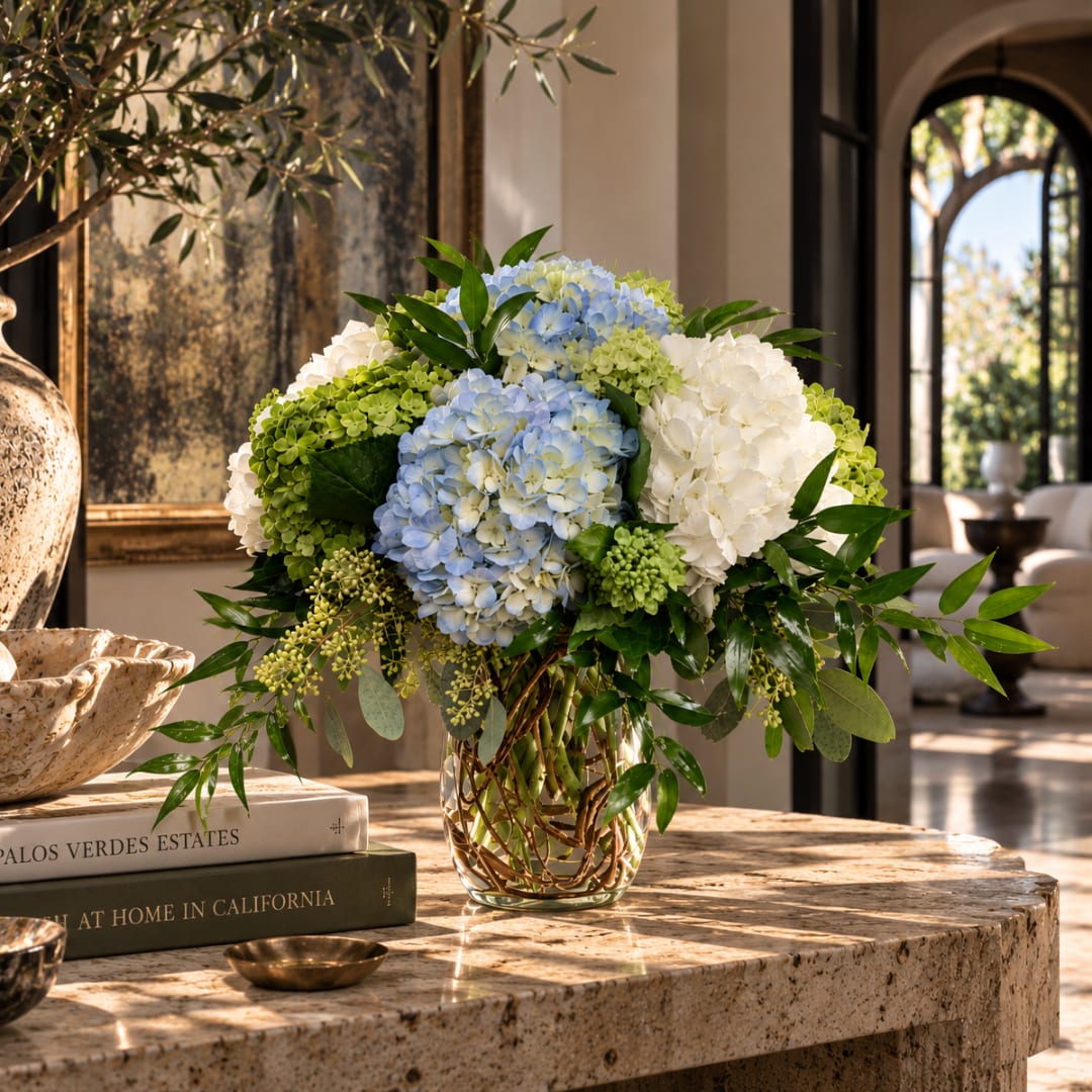 Blue and white hydrangea arrangement in a glass vase