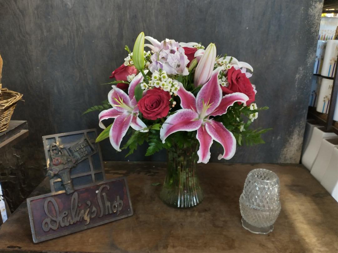 Bouquet of pink lilies and red roses in a glass vase