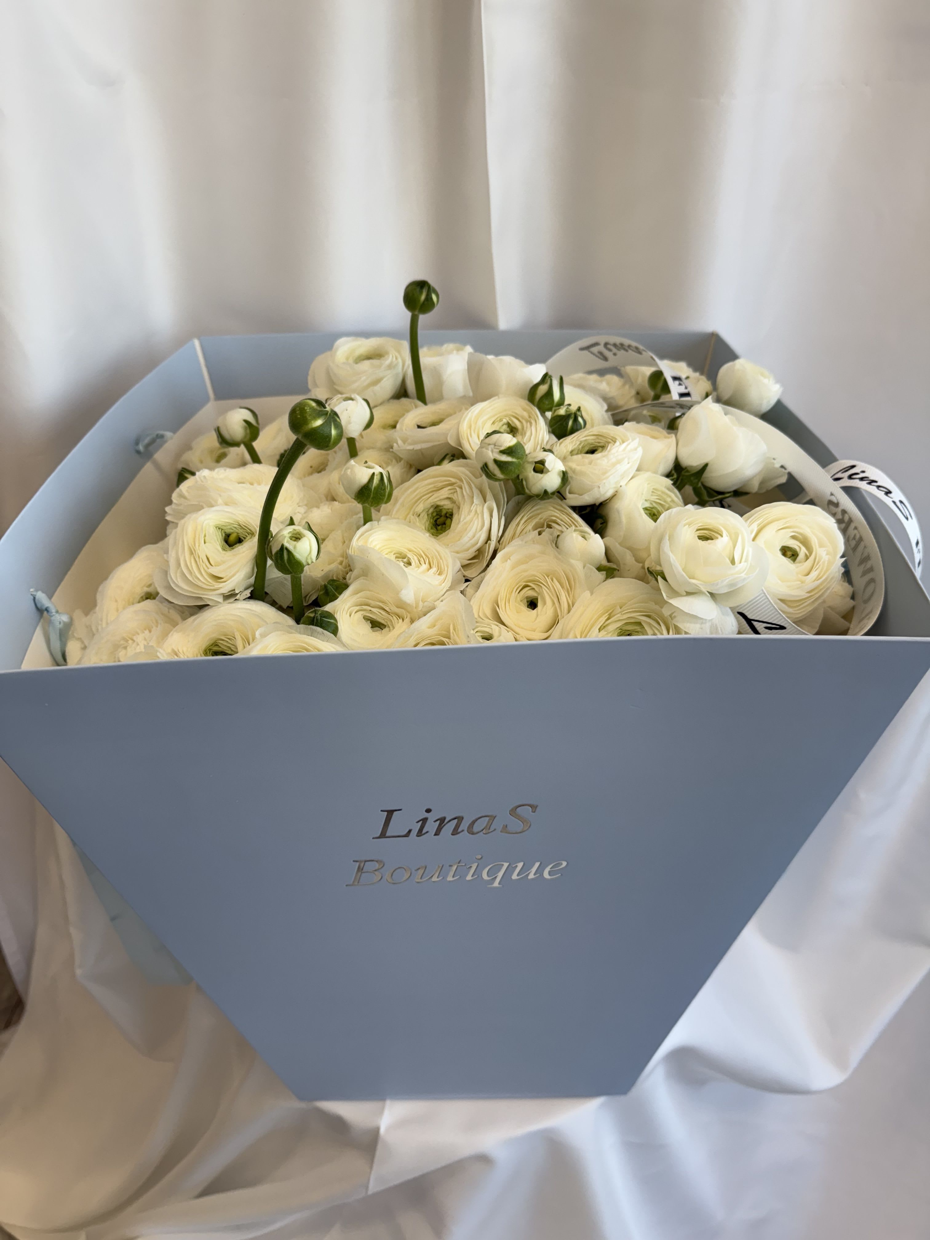 White ranunculus bouquet in a light blue box