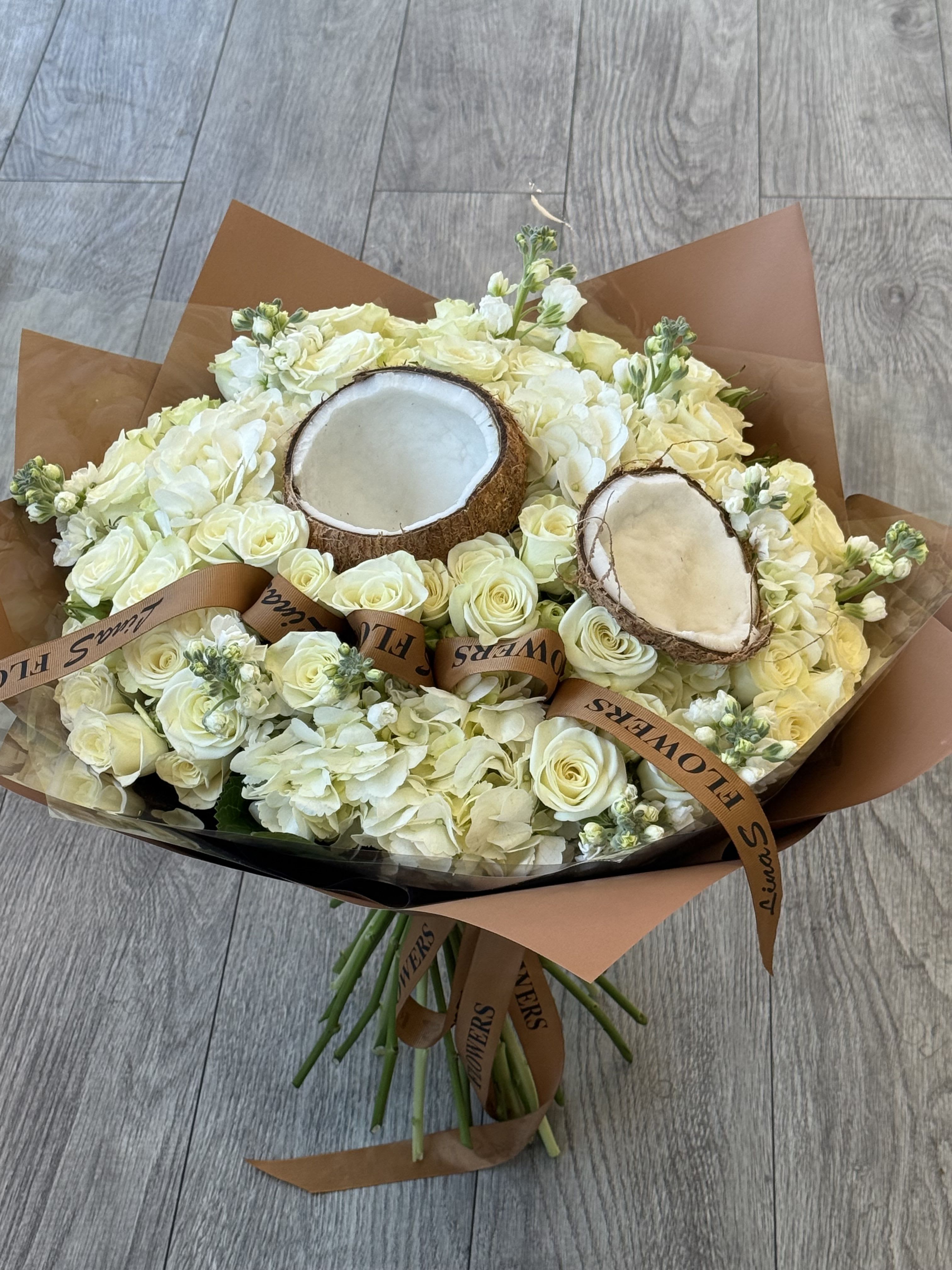 Bouquet of white roses and hydrangeas with two coconut halves