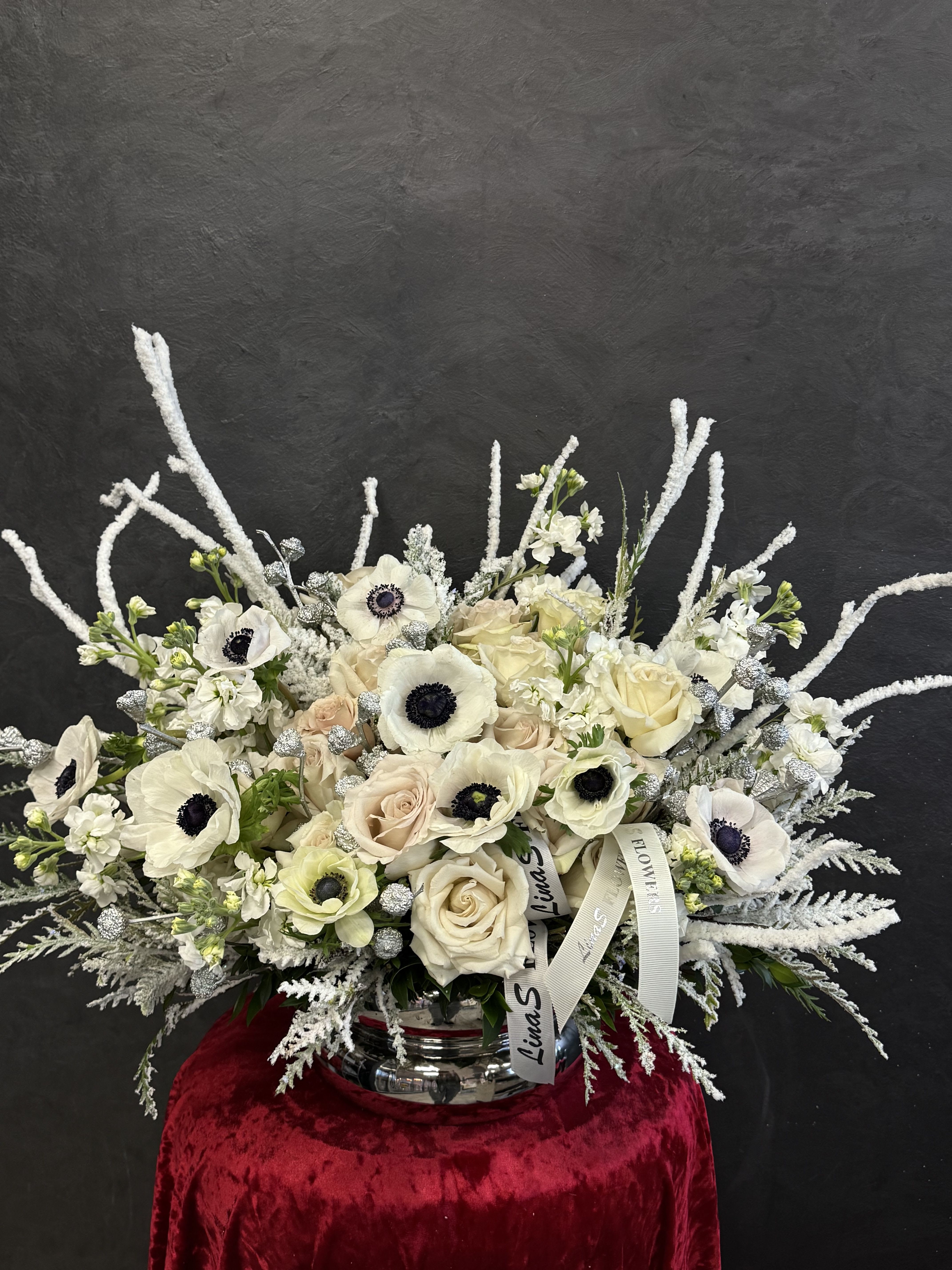 White and blush bouquet with anemones and roses in a silver vase
