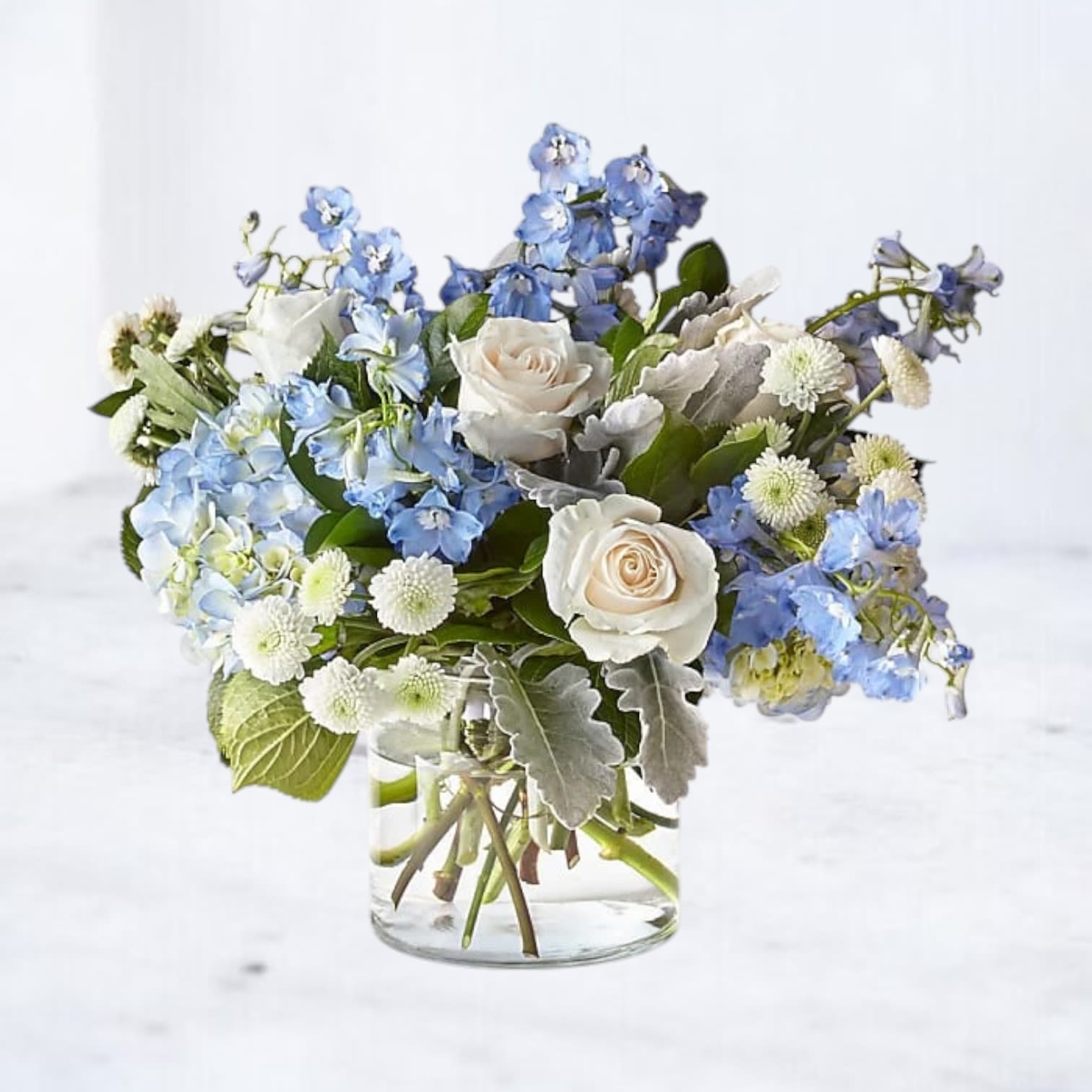 Blue and white flower arrangement in a clear glass vase