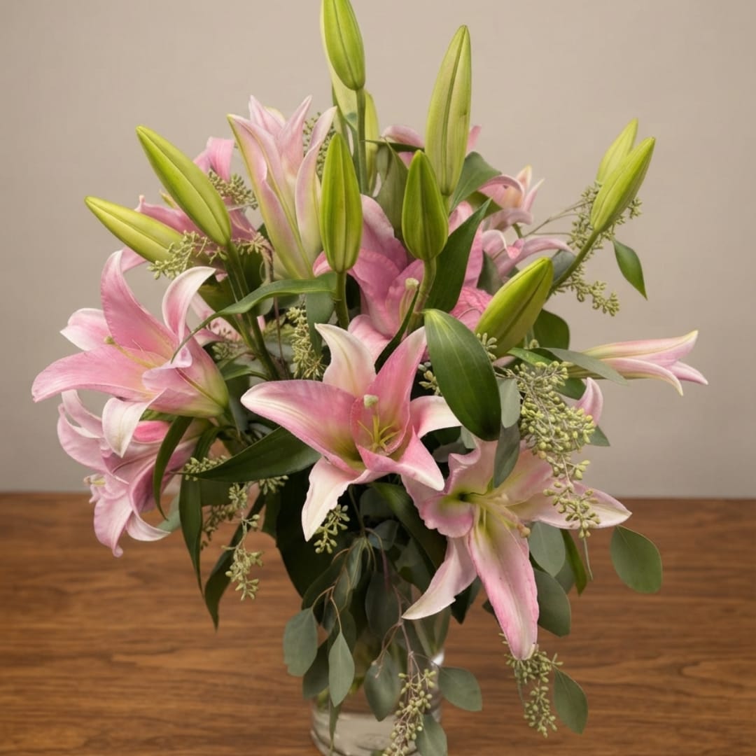 Pink lilies arranged in a clear glass vase