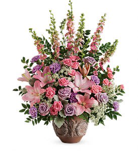 Tall pink and lavender floral arrangement with lilies and roses in a decorative brown pot