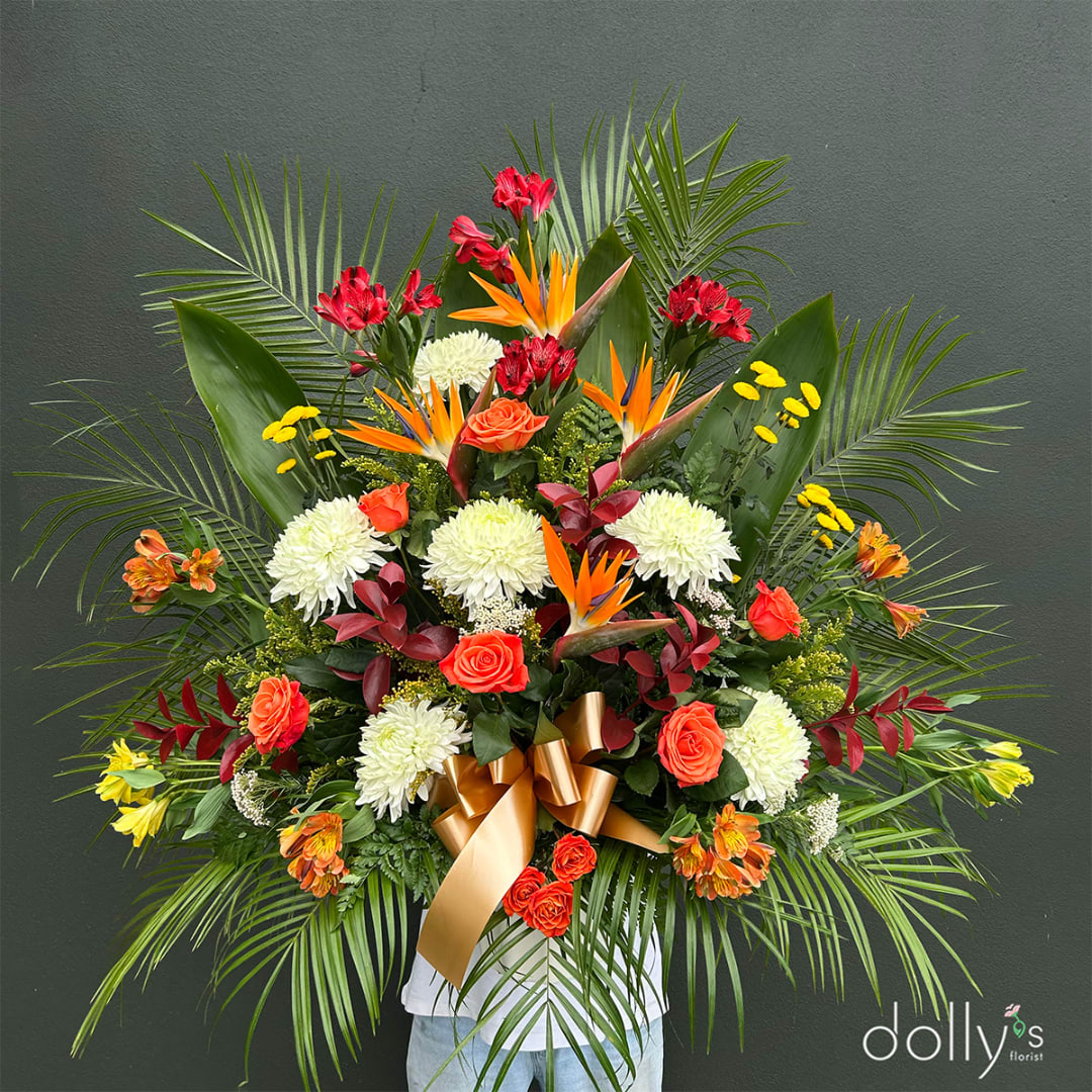 Large tropical floral arrangement with roses, chrysanthemums, and bird-of-paradise