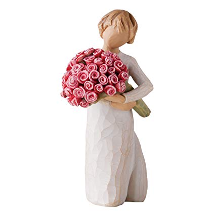 Figurine of a woman holding a bouquet of pink roses