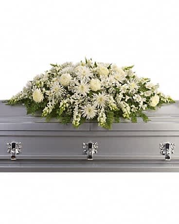 White floral casket spray on a gray casket