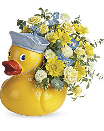 Yellow duck-shaped vase holding yellow and blue flowers
