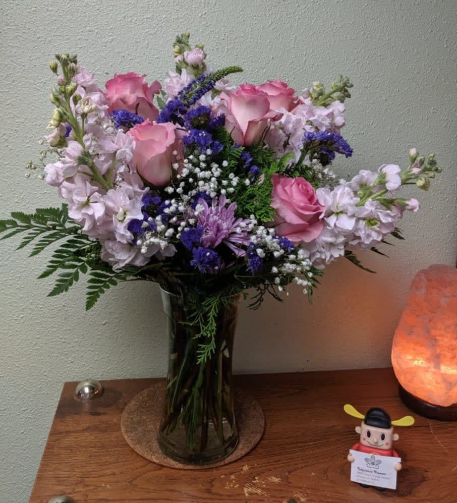 Dreaming in Pastels  - This sweet arrangement of the pastel palette to warm the heart and express your love. An elegant arrangement of lavender stocks, pink roses, and purple accents, it soothes and calms that special someone. 