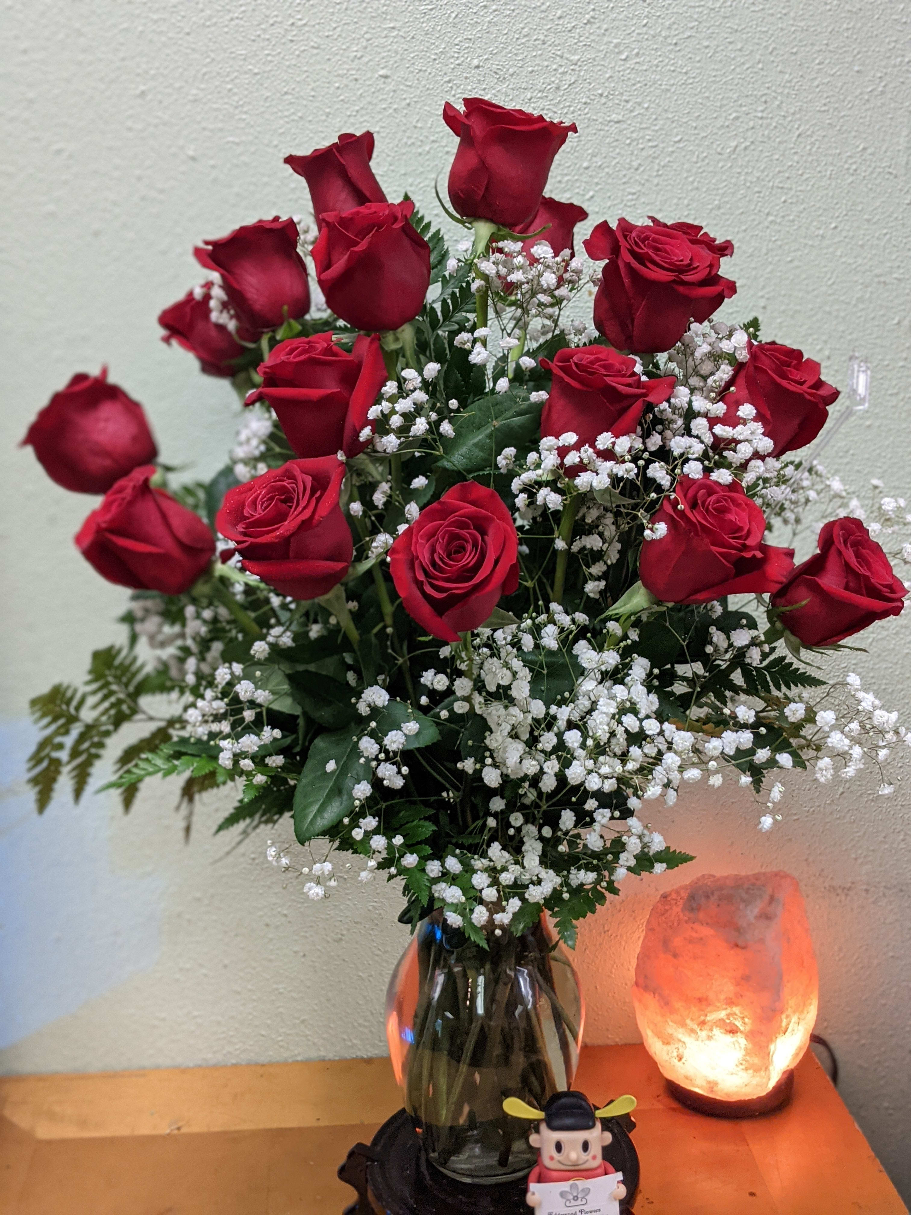 Red roses with white baby's breath in a glass vase