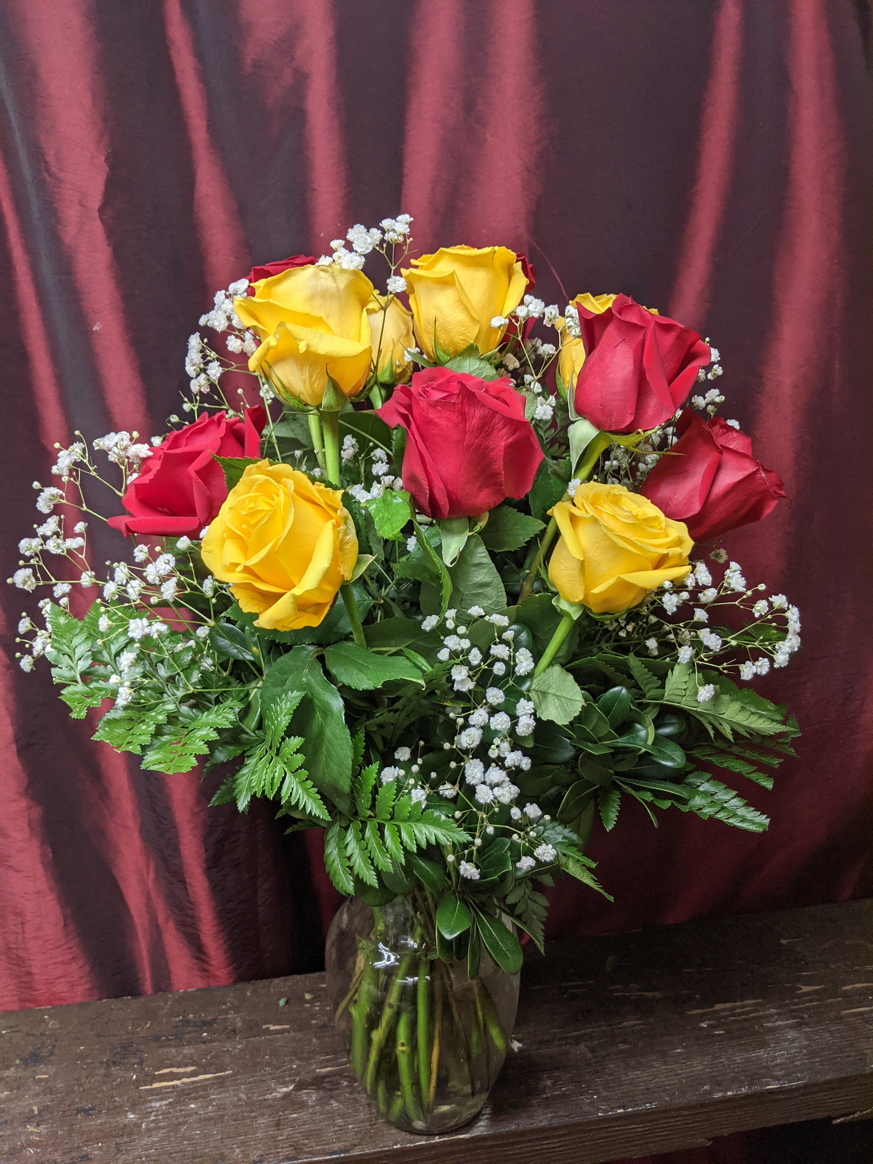 Bouquet of red and yellow roses in a glass vase