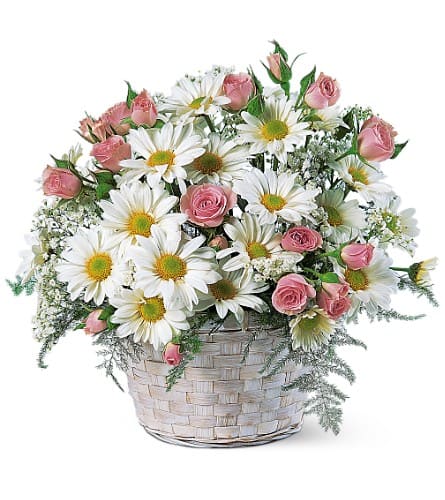 Pink roses and white daisies in a woven basket