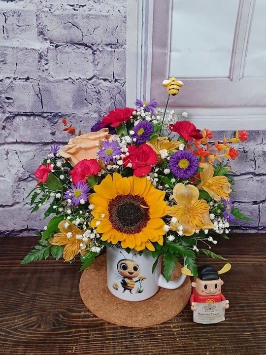 Sunflower bouquet in a mug with a small bee figurine