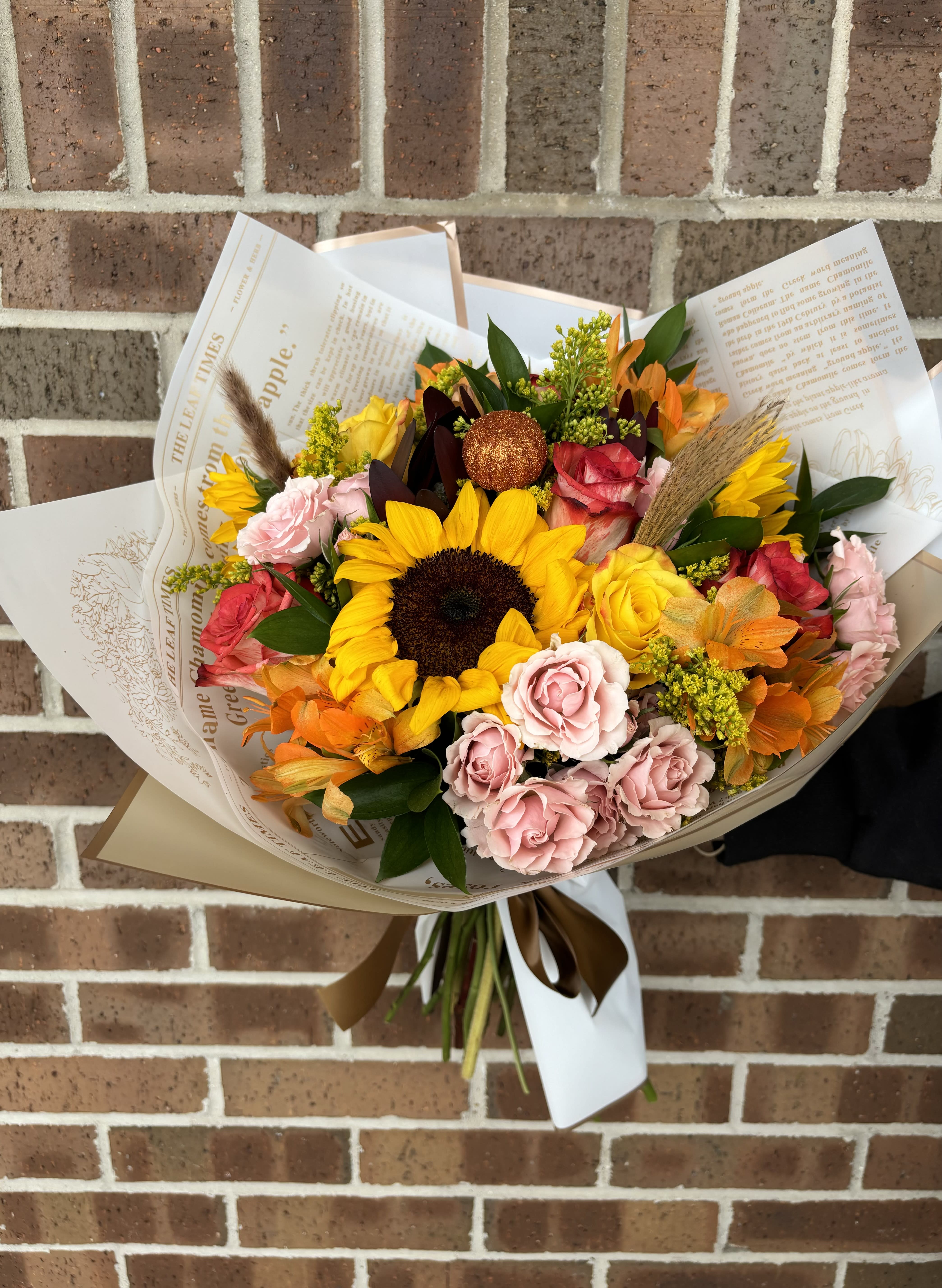 Harvest Garden Wrapped Bouquet  - Greet the new season with this heartwarming sunflower and rose bouquet with other fall mix flowers, presented beautifully as a wrapped bouquet. 