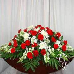 Red and white floral casket spray with palm leaves