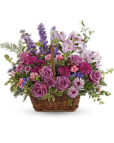 Purple floral basket arrangement with roses and lilies
