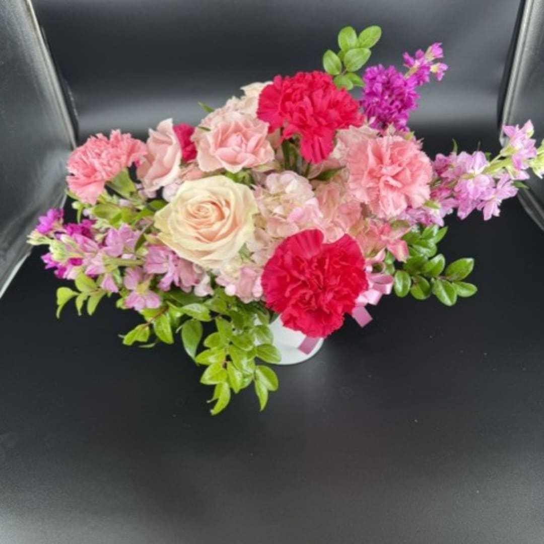 Pink and red floral arrangement in a white vase