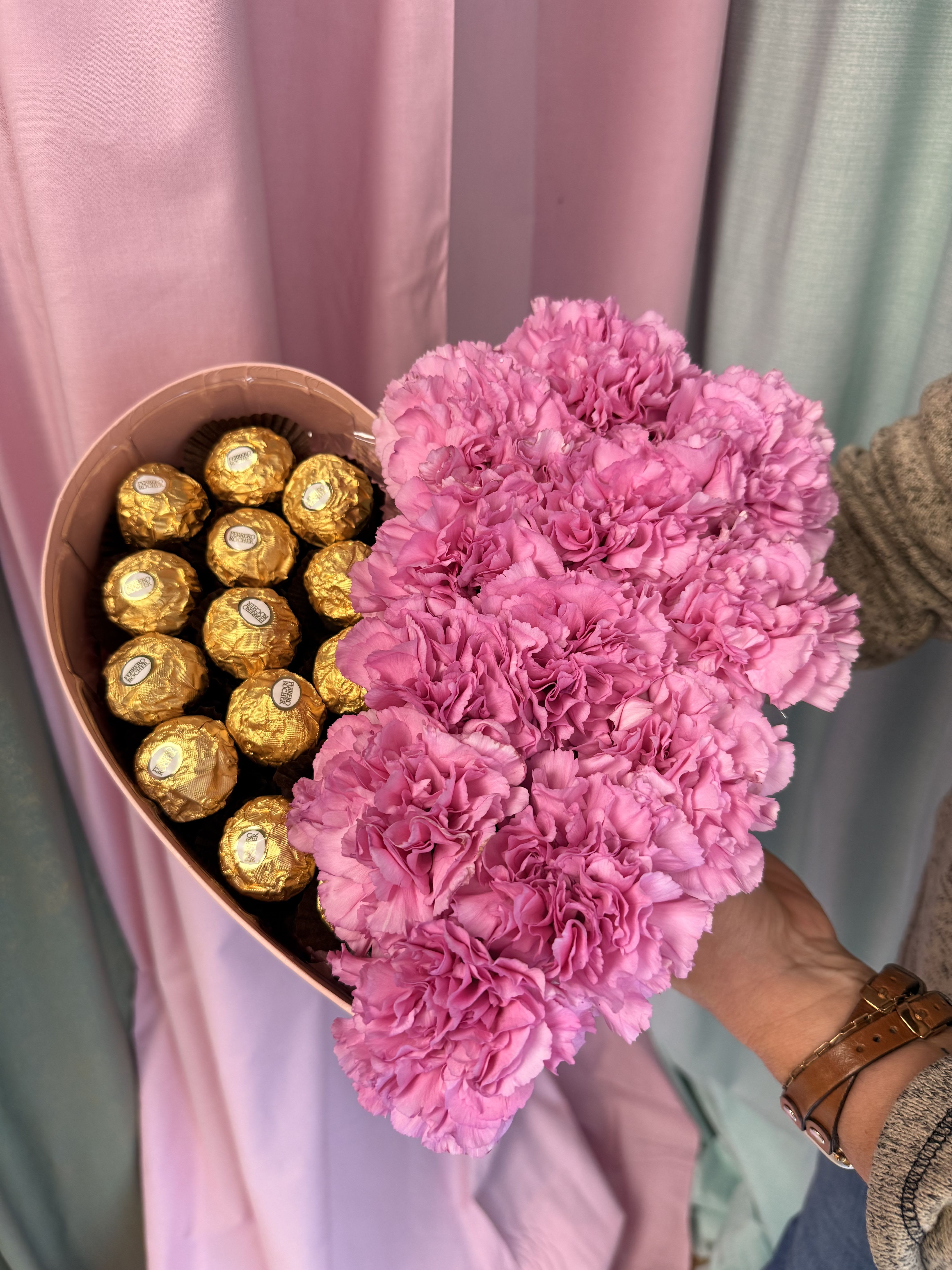 Indulgent Heart Bouquet- Assorted Color Carnations - *Number &amp; colors of carnations may vary because of variety &amp; size of carnation. If you want specific color of box or flowers call us at (574) 722-1155  Our heart-shaped containers are the perfect blend of romance and indulgence. On one side, fresh, beautifully arranged flowers bloom with color and fragrance; on the other, rich, decadent chocolates wait to be savored. Thoughtfully designed to delight both the eyes and the taste buds, this all-in-one gift says “I love you” without needing a single extra word. Perfect for anniversaries, Valentine’s Day, or any moment you want to make unforgettable.  