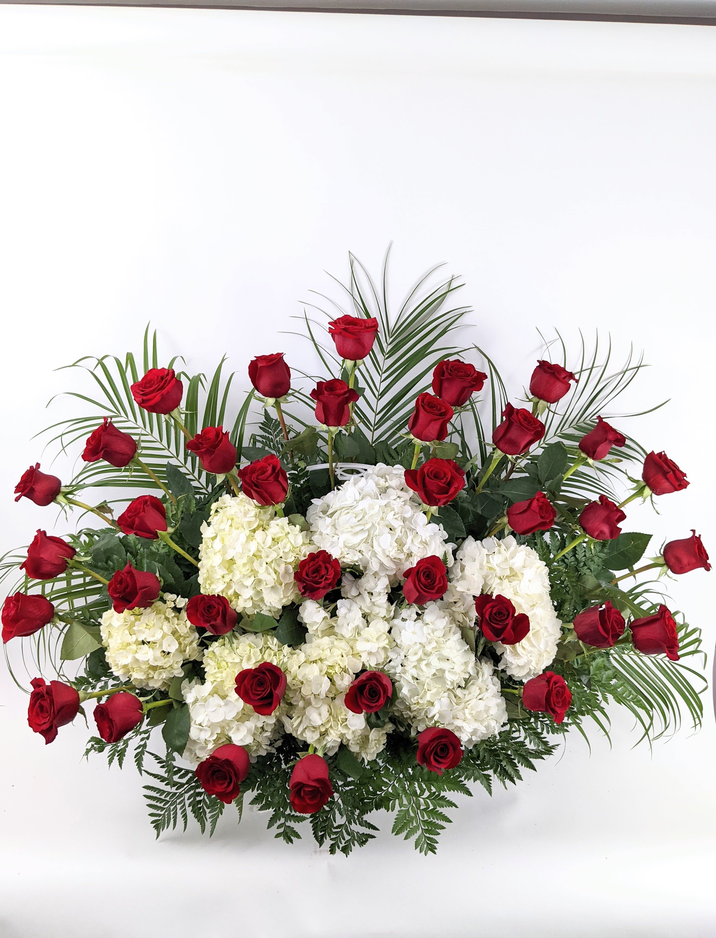 Warm Remembrance Basket - Warm Remembrance basket includes: White Hydrangea Red Roses  Colors can be substituted based on availability.   This type of design is usually approximately 3ft x 3ft and is meant for funeral services ONLY. This design includes a free banner (please include a banner sign in the Special Instruction Box or Message Box with the title “BANNER”).  In the event a banner space is left blank for any reason, ONLY a card message will be included. Banners are printed in a black 2.5-inch wide ribbon with silver ink. Currently, we don't offer any other colors. If the service is the same day as the order was placed we cannot guarantee delivery by a certain time. And flowers will be delivered during normal business hours.  To ensure the delivered flowers match the displayed photo as close as possible we recommend ordering 3-5 days in advance. For the same or next day deliveries, we reserve a right to substitute flowers with the same or greater value. Please read our substitution policies below.
