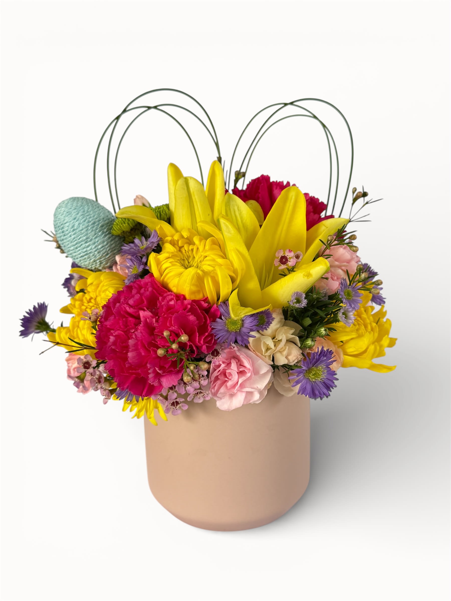 Springtime Joy - Bursting with cheerful color and seasonal charm, this arrangement features vibrant yellow lilies and bright pink carnations, soft blush roses, and delicate purple accents.