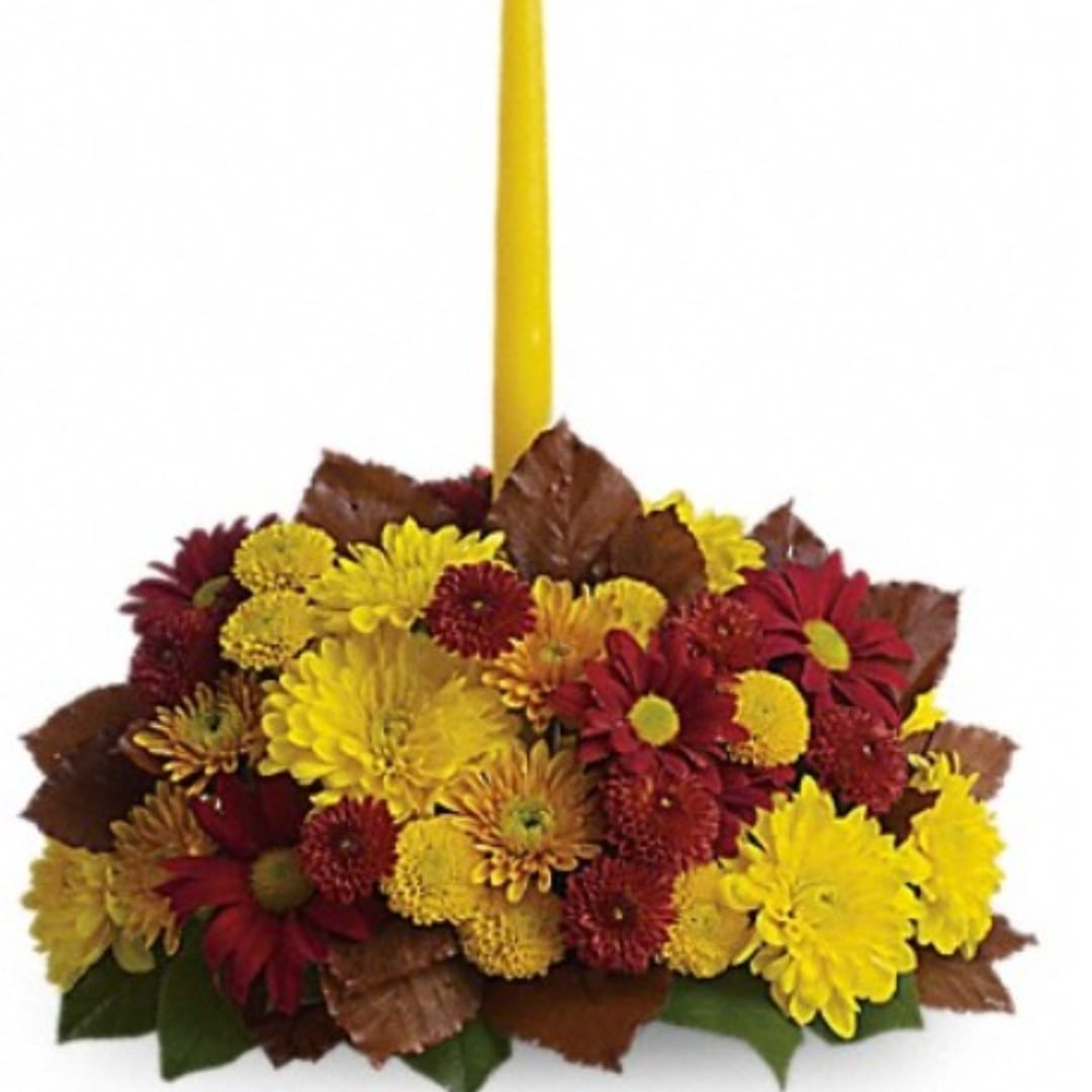 Yellow and red chrysanthemum arrangement with a tall yellow taper candle