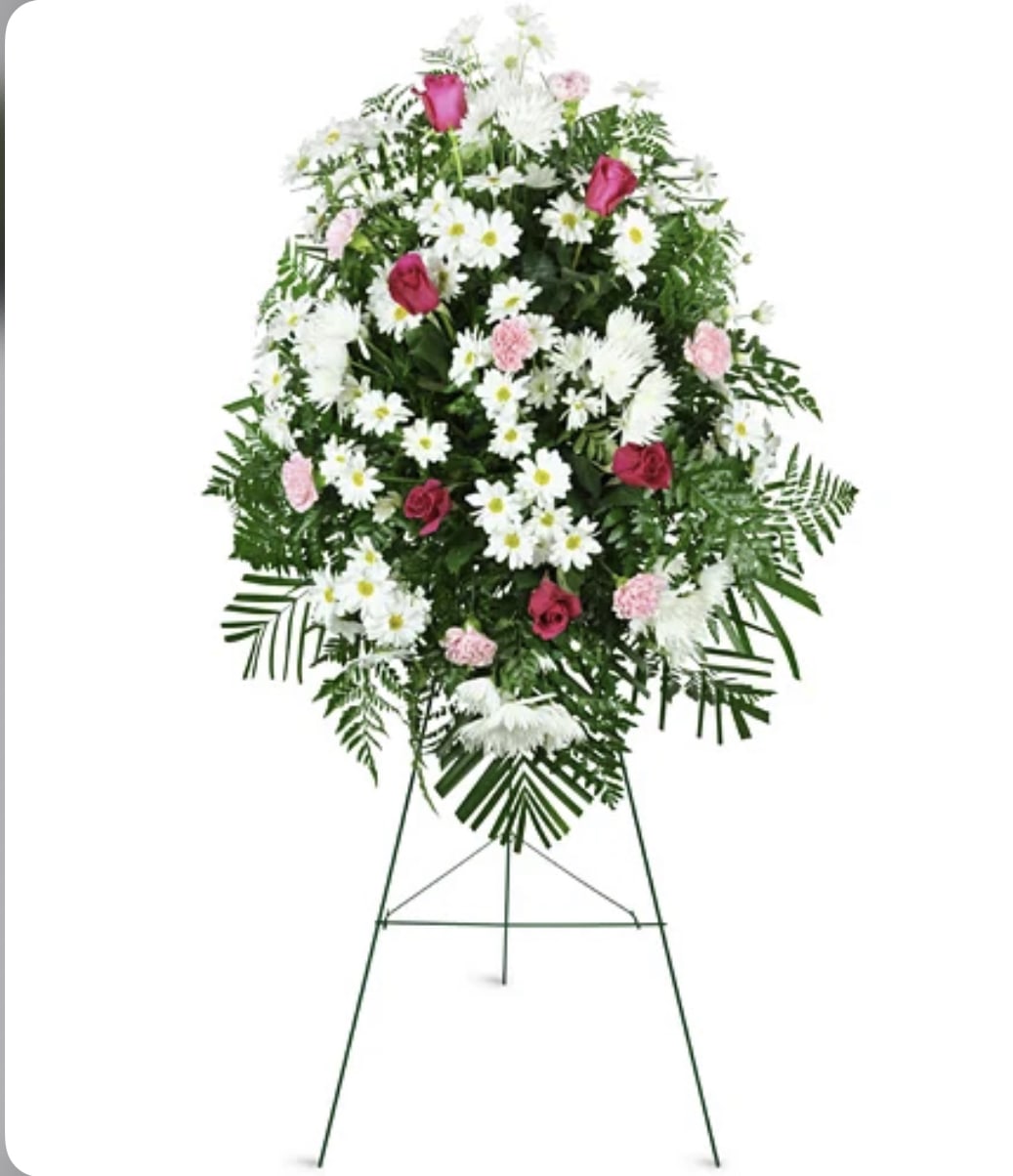 Standing floral spray with pink roses, white daisies, and greenery on an easel