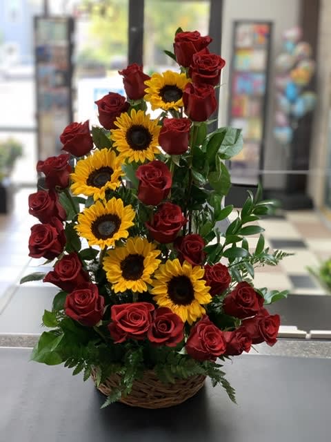 Basket arrangement of red roses and sunflowers