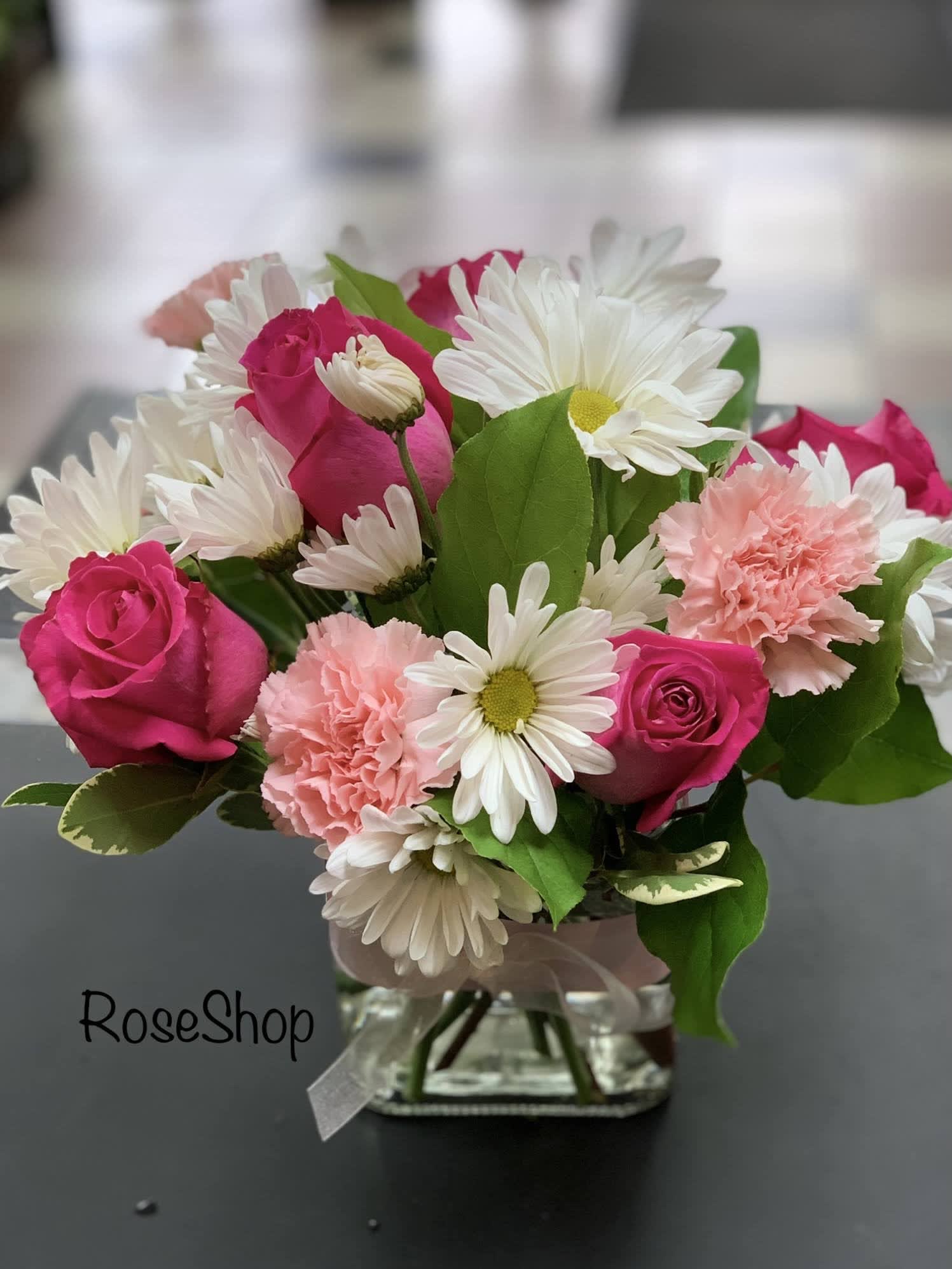 Pink roses and white daisies in a glass vase